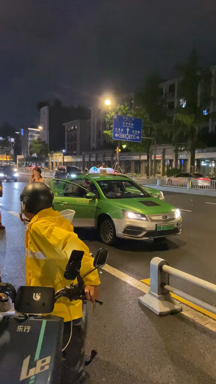 夜晚街头一女子哭着打电话说他打我,旁边停着一辆出租车.