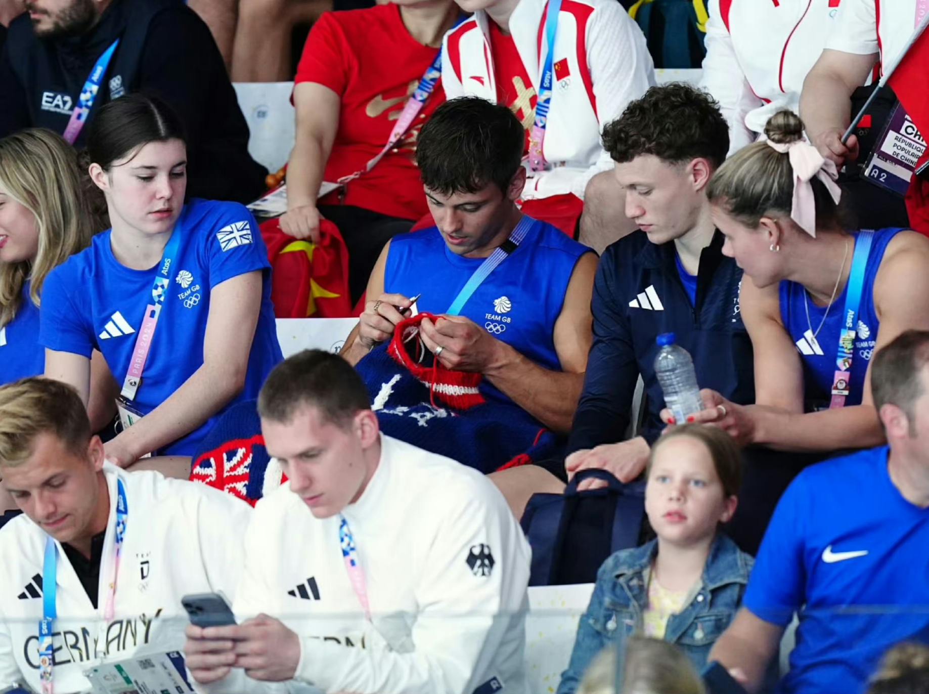 英国跳水王子 汤姆·戴利在观看女子跳水比赛,一边编织羊毛套衫,一边