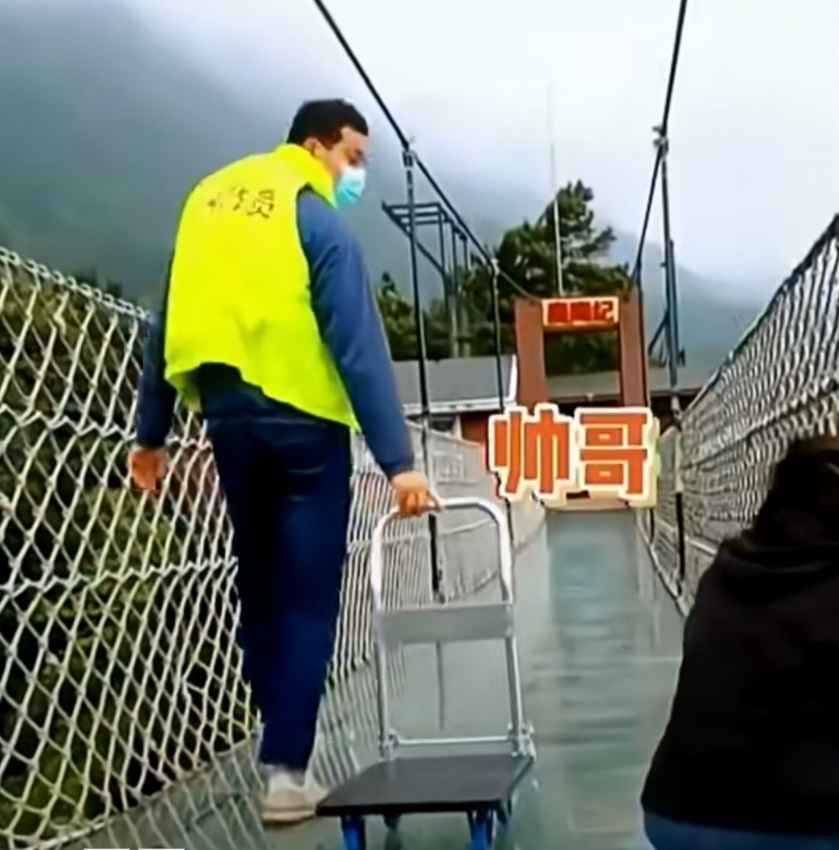 景区的玻璃栈桥上,女游客吓破了胆,坐在桥上动都不敢动,刚好有个男