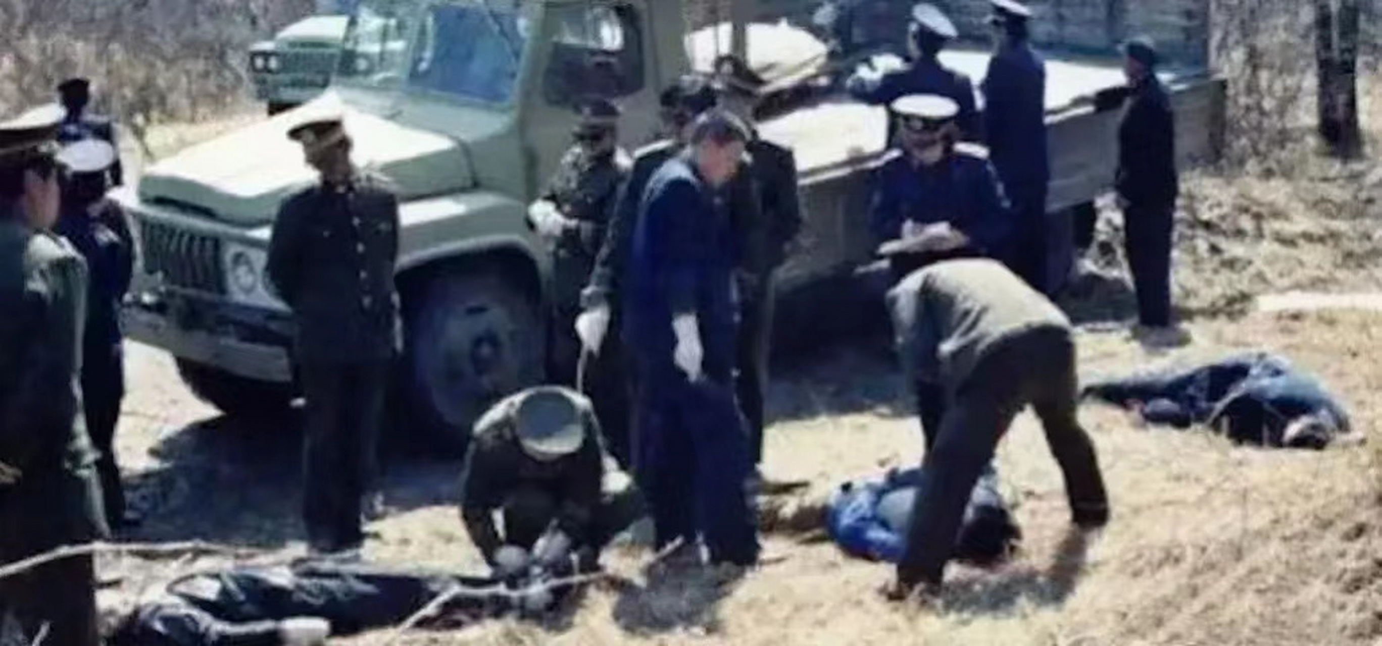 90年代,露天刑场行刑过后的照片,武警战士正在给死刑犯们解开法绳.