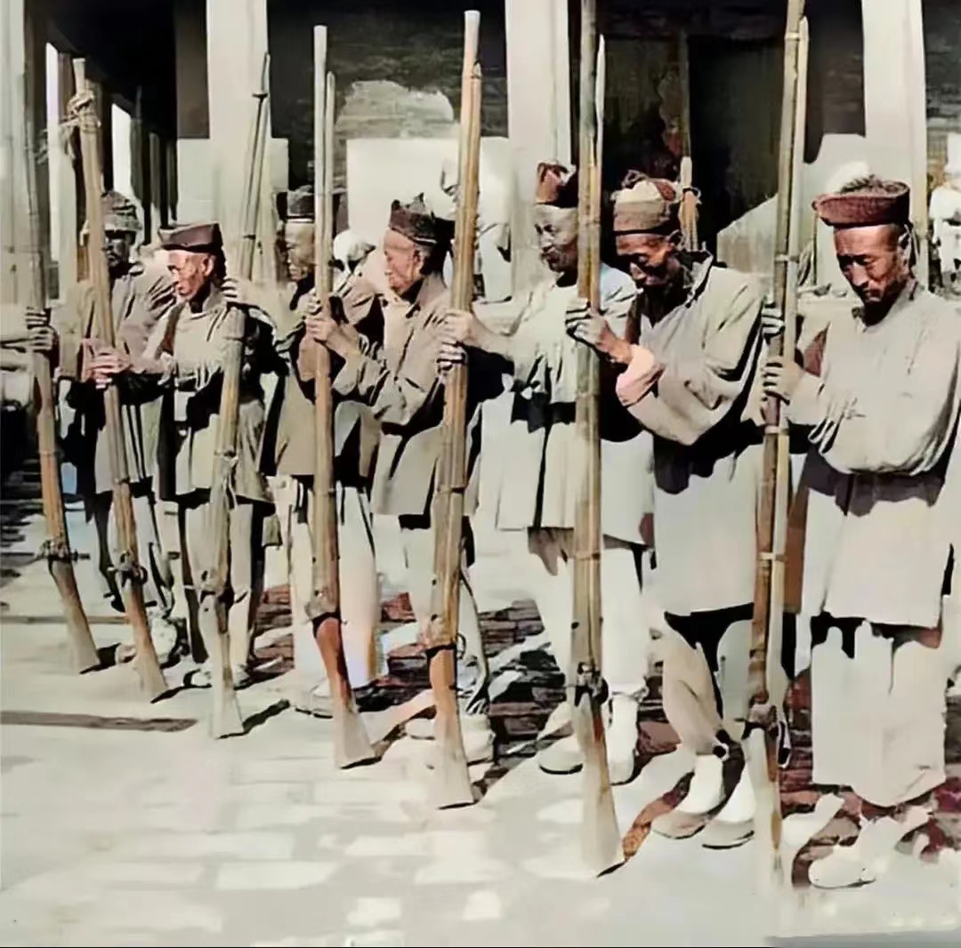 一群衙役手拿"抬枪"的照片,镜头中的衙役的面容和身姿,都透露出一种