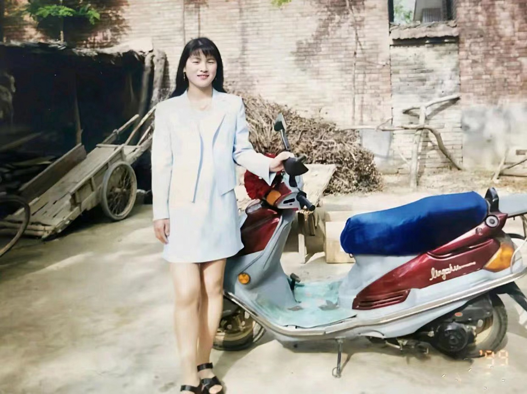 90年代,一个年轻姑娘站在她的踏板摩托车旁,留下了一张珍贵的合影.