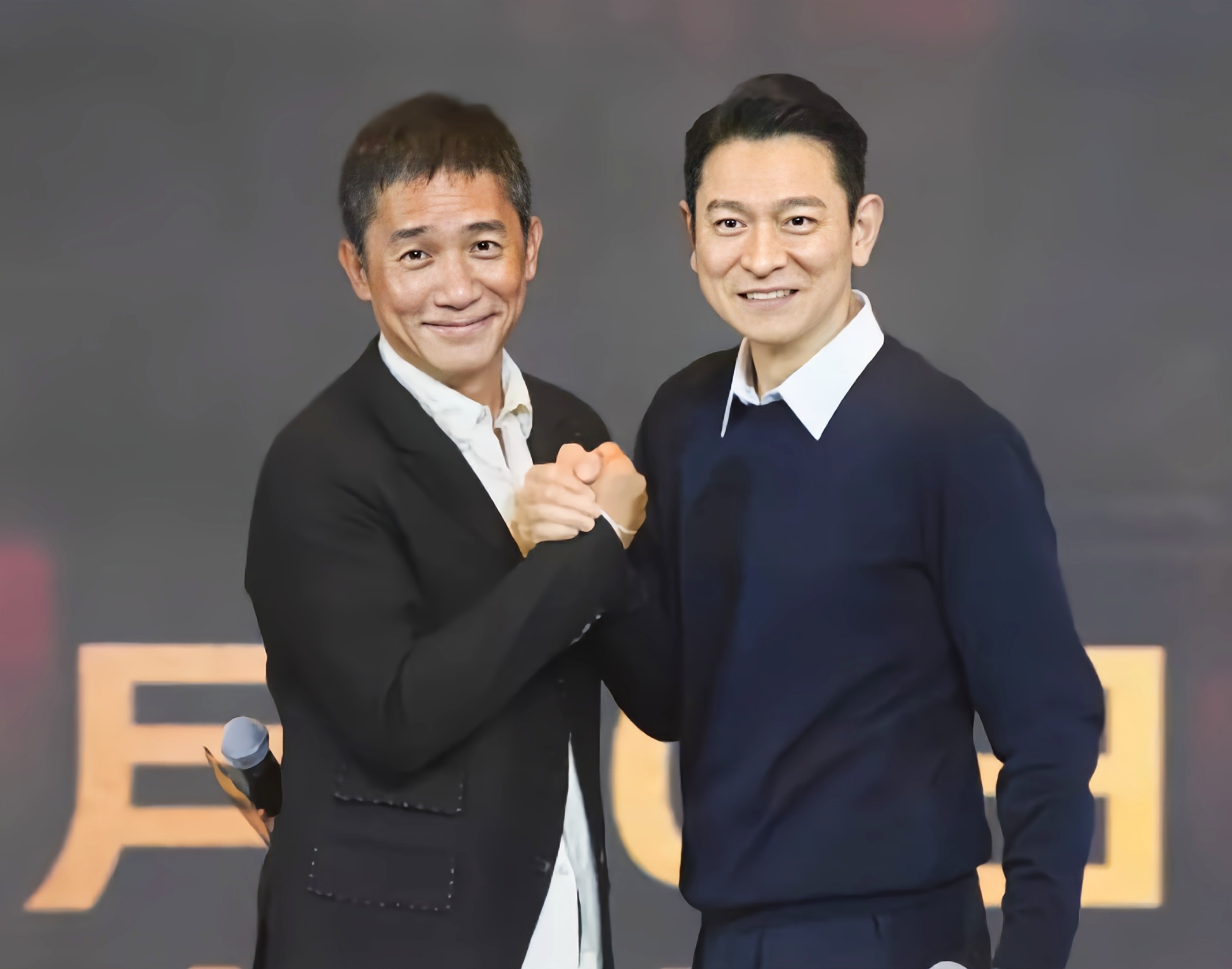 刘德华与梁朝伟的手紧紧握在一起,兄弟连心,其利断金
