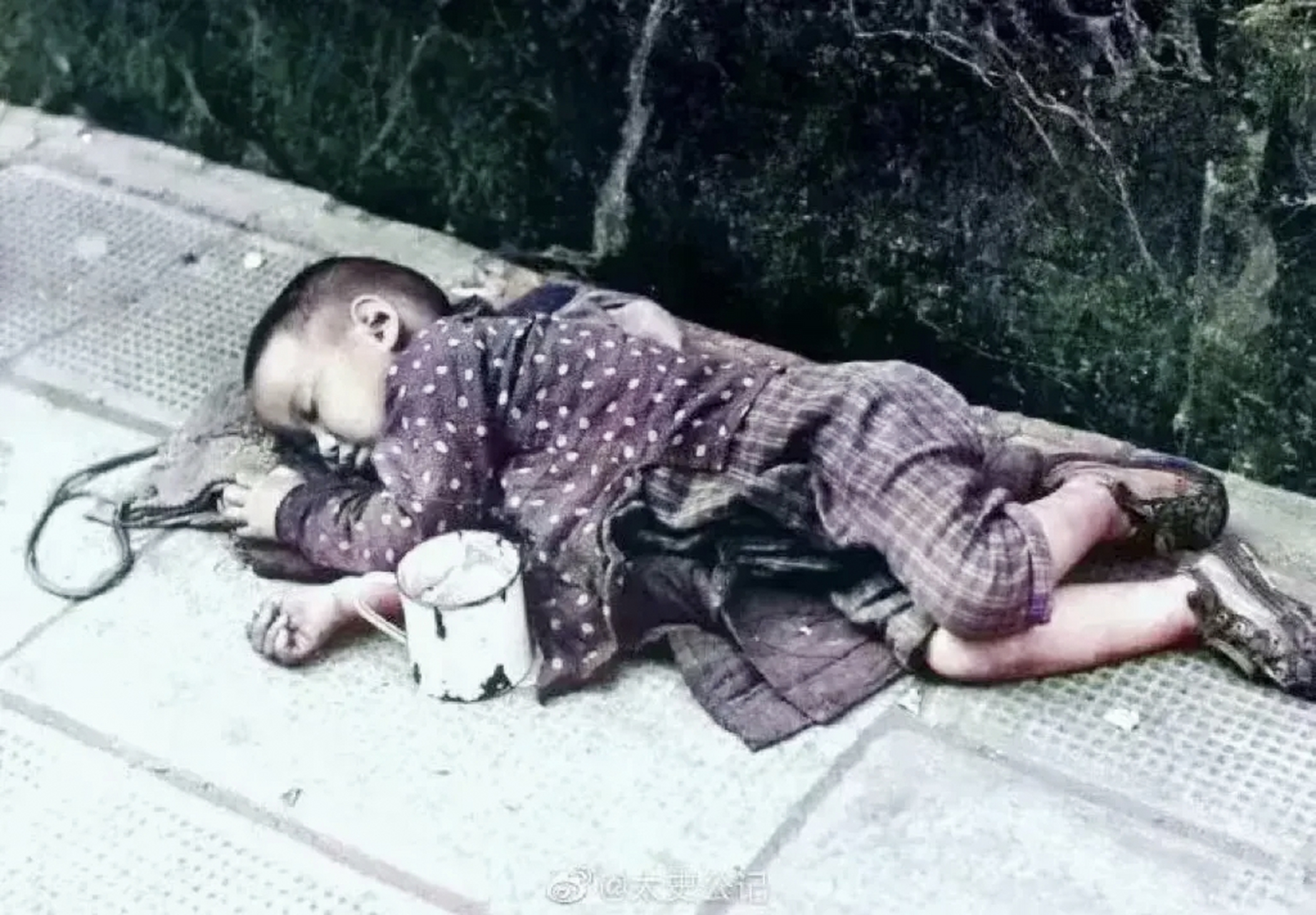 1948年,上海街头,一个衣衫褴褛的小男孩躺在地上