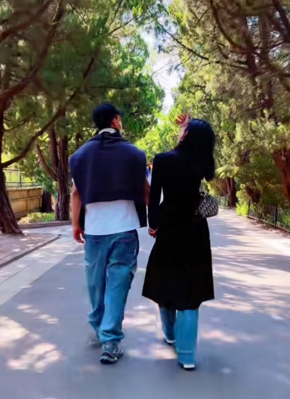 王灿和老公牵手散步,杜淳穿短袖了她还捂着大衣,两口子不是一个季节.