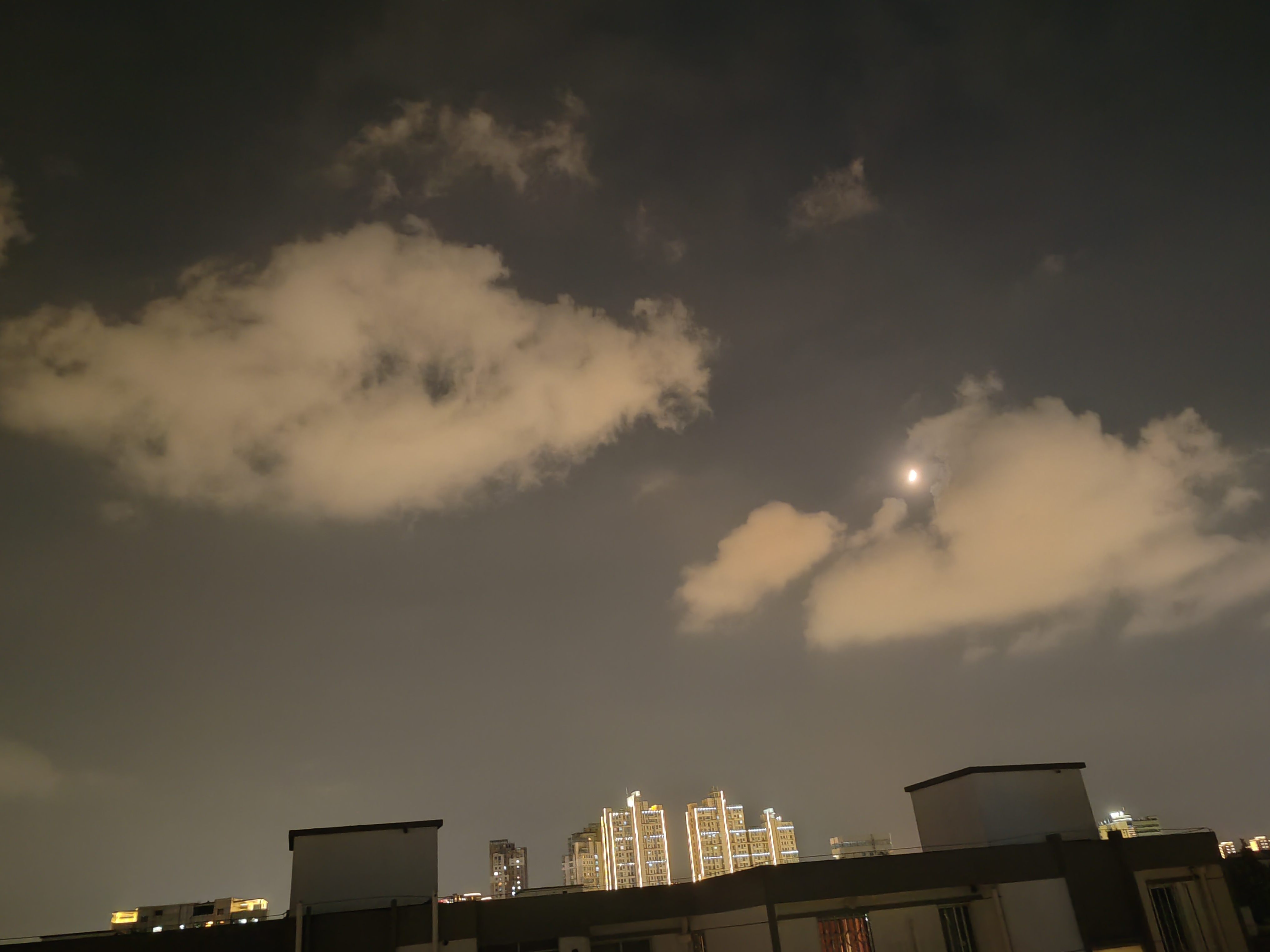 刚立秋后不久,晚上7点多,城市中天空的月亮和云彩