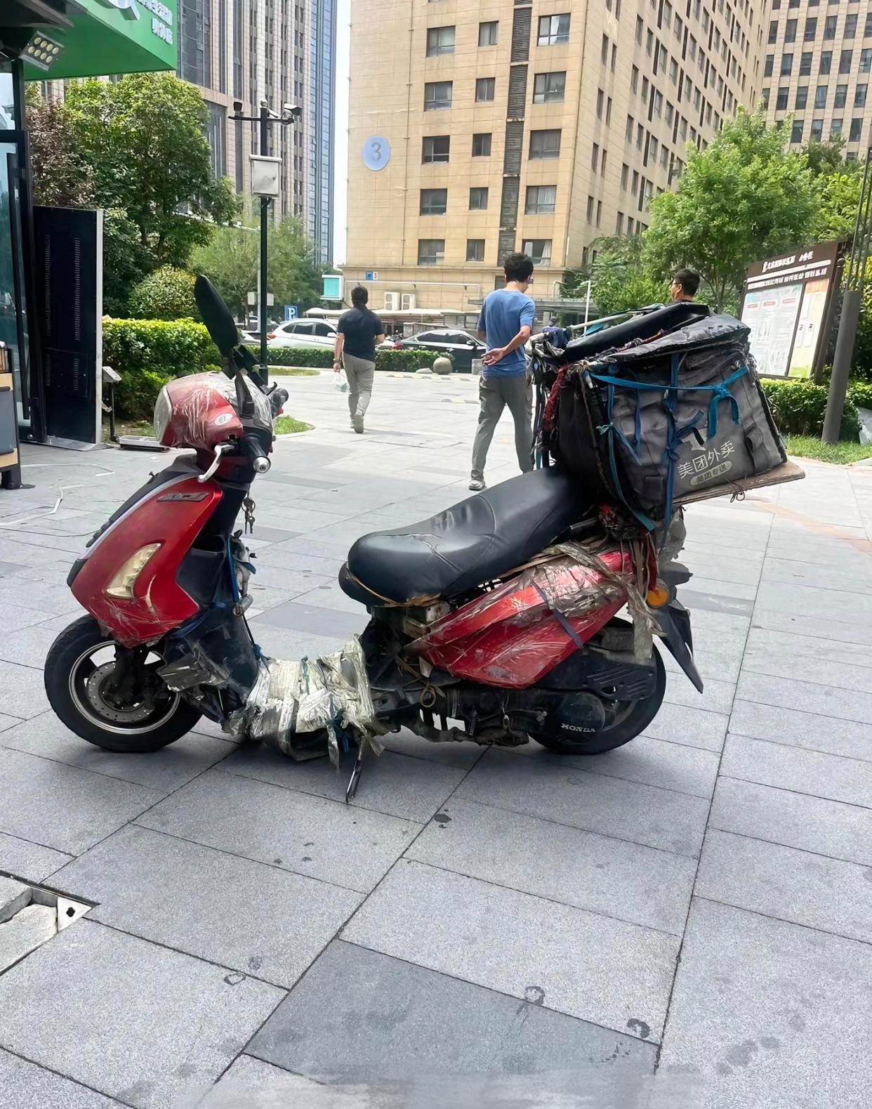 他骑着一辆看起来十分老旧的电动车,车身的漆皮有些剥落,零件也似乎在