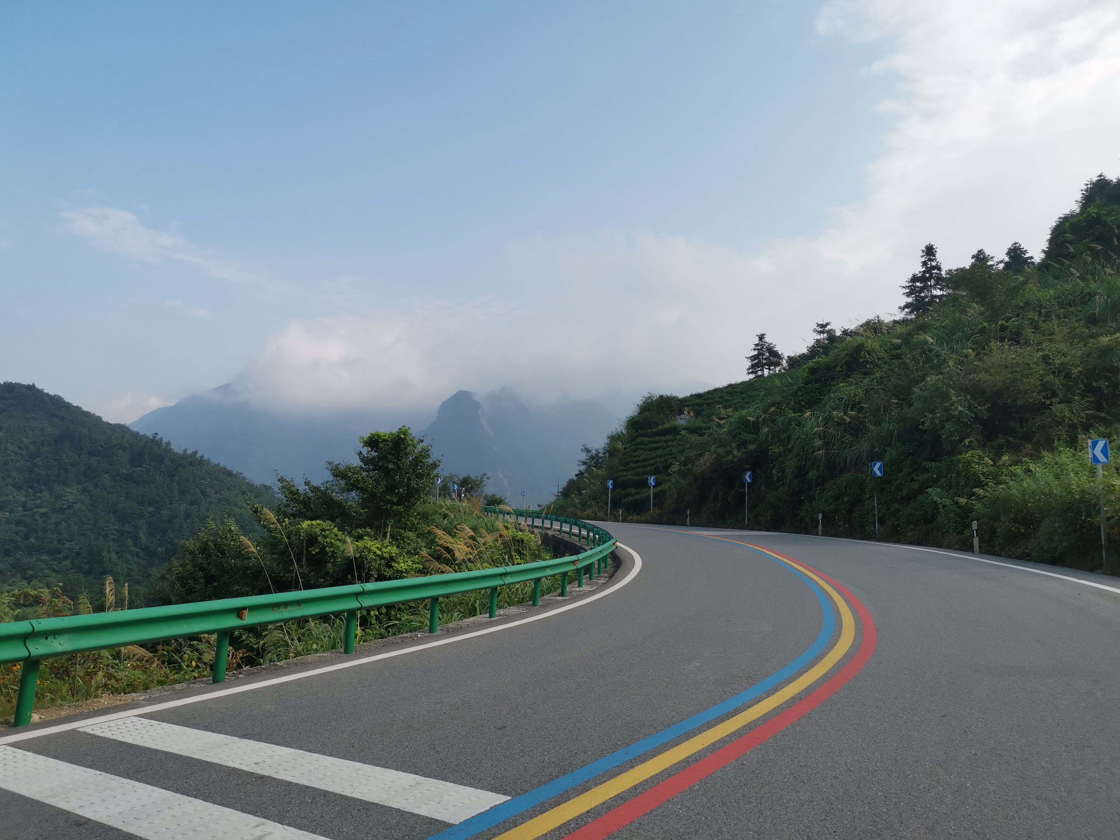 骑行安庆岳西明堂山,g318国道在山腰上蜿蜒盘旋,山上雾气腾腾,堪比