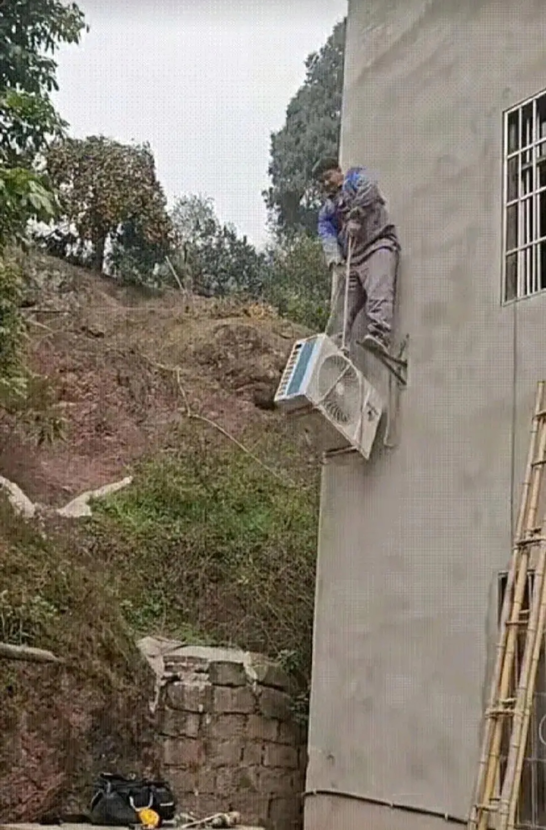 大热天的,这位师傅汗流浃背地安装空调,折腾了好久还没弄好