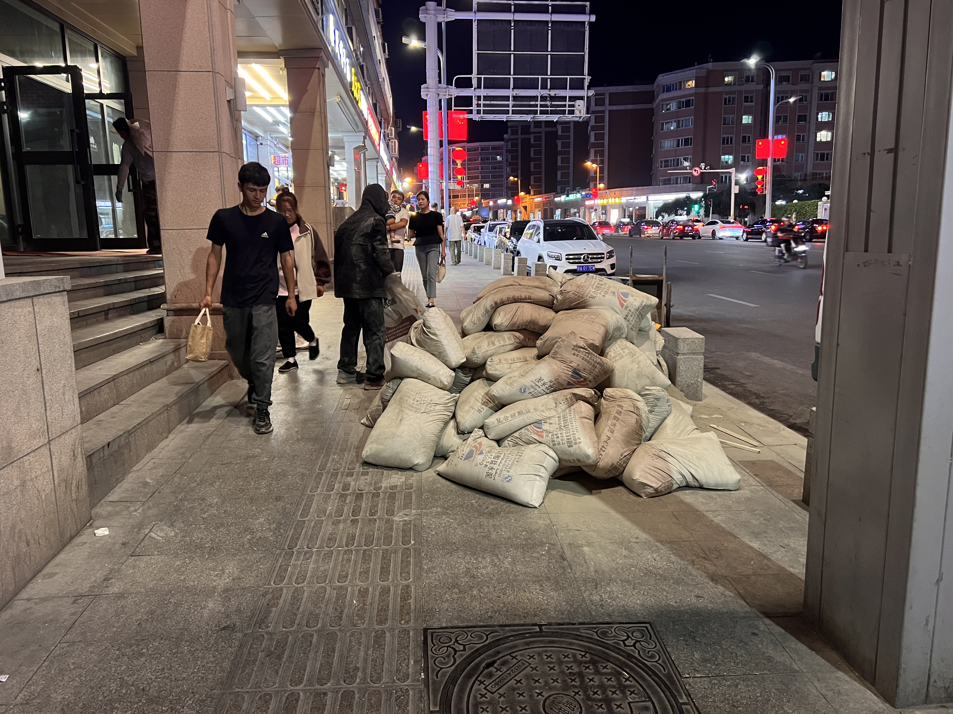 街头,昏黄的路灯下,两个装修工人正忙碌着,在微凉的风中,与街头的灯火