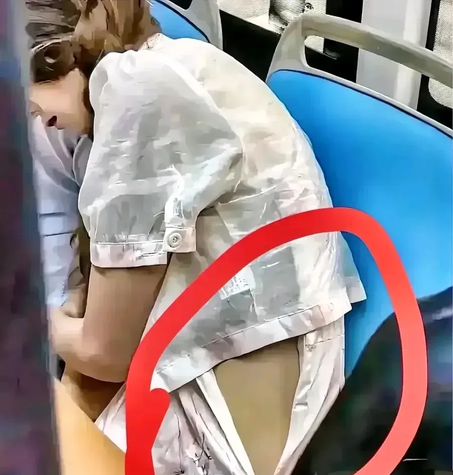 公交车上,一位漂亮优雅的女士,裙子侧面的拉锁忘记拉上了,她正低头玩