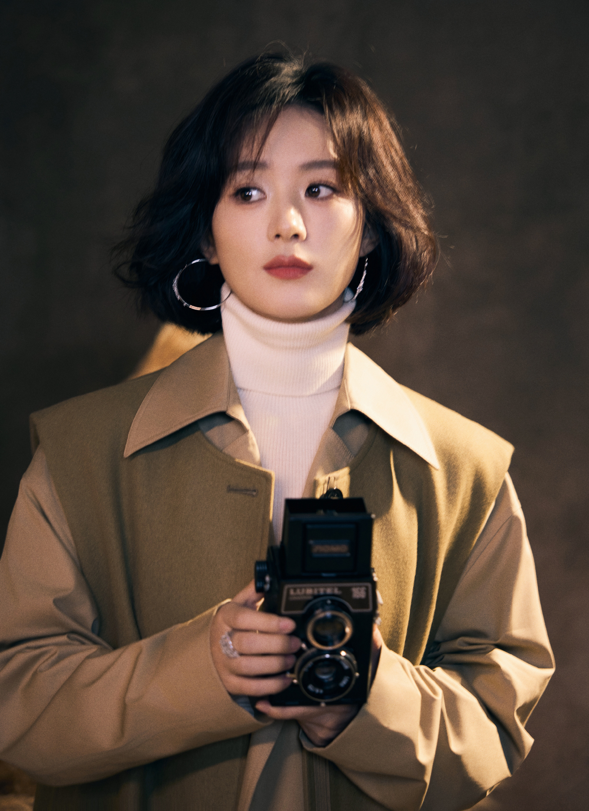 在这组大片中,赵丽颖叠穿褐色大衣,内搭高领针织衫,造型优雅又知性