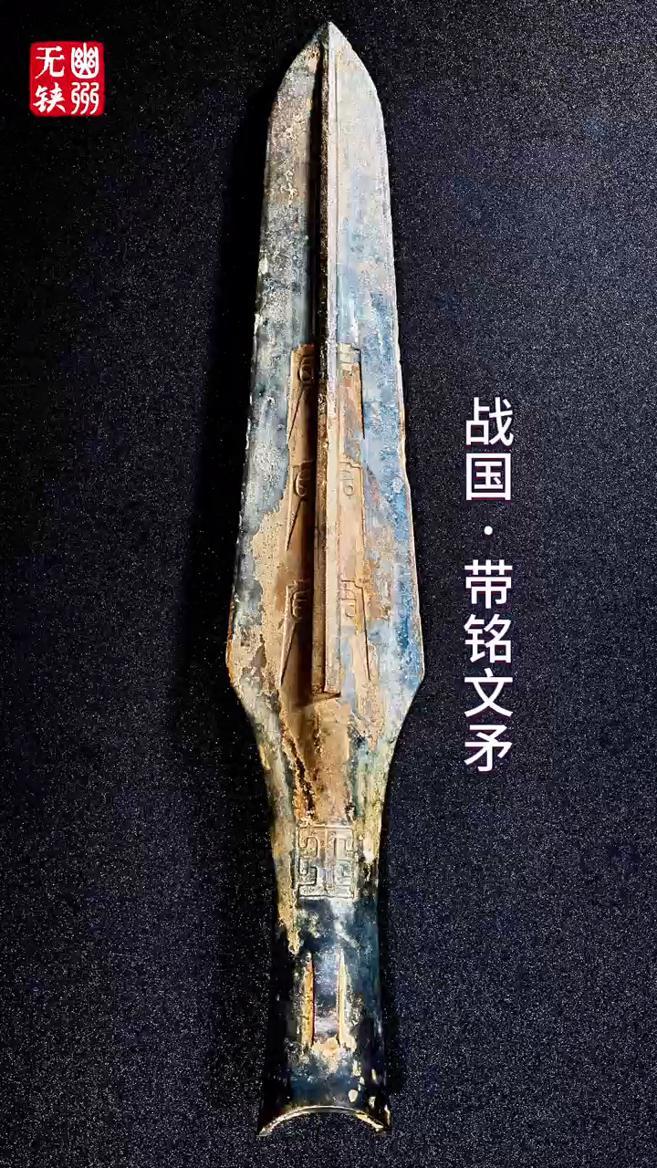 战国·带铭文矛 长22.7厘米通体宽扁且直,中部起脊,直刃前聚锋