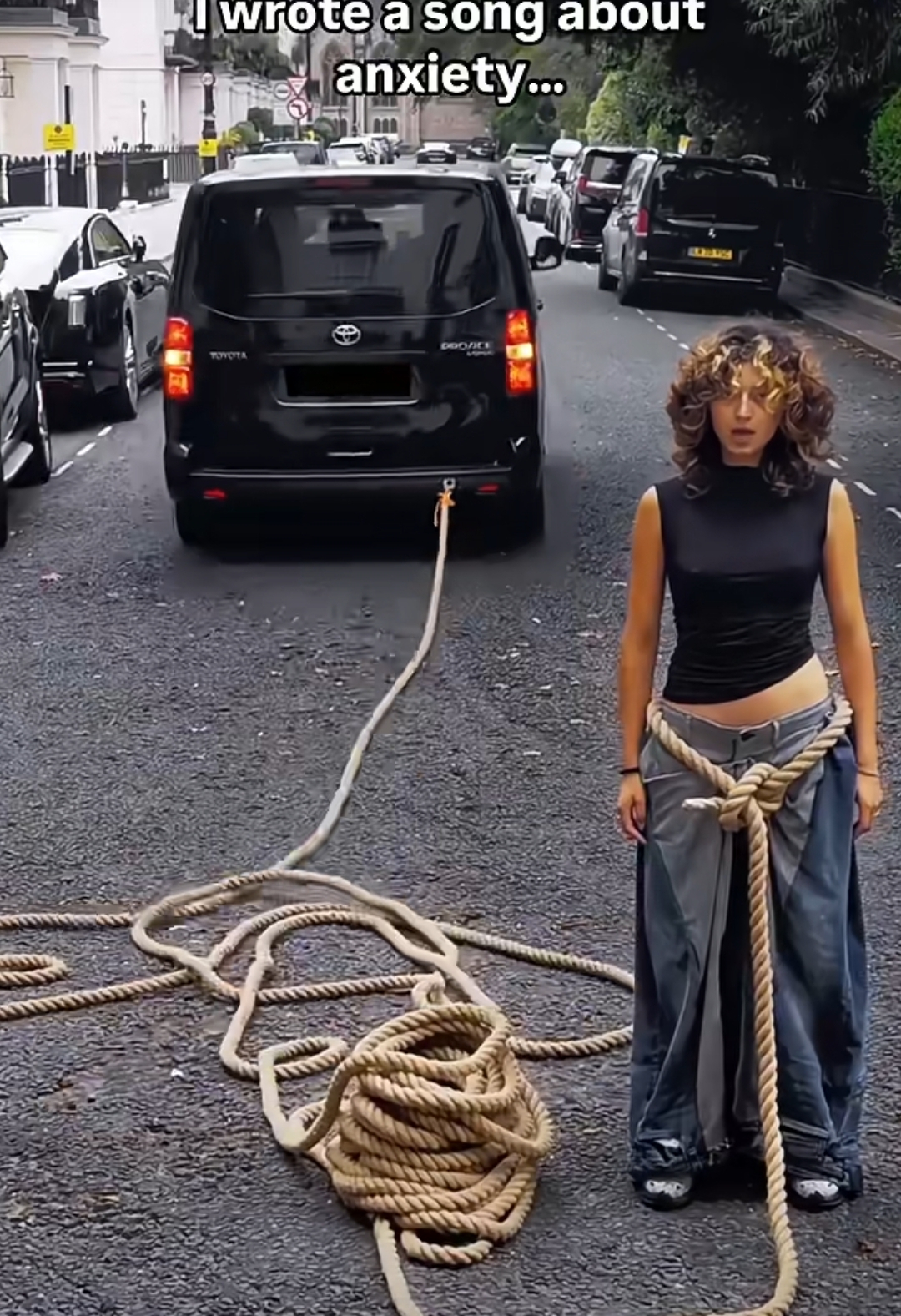 大家看看这个汽车上系着绳子后面一个女人腰间系了好多绳子,让汽车拉