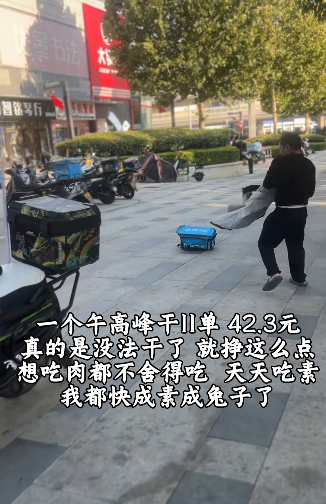 外卖小哥停下电动车把尾座上的外卖箱取下来往地上狠狠摔了好几次