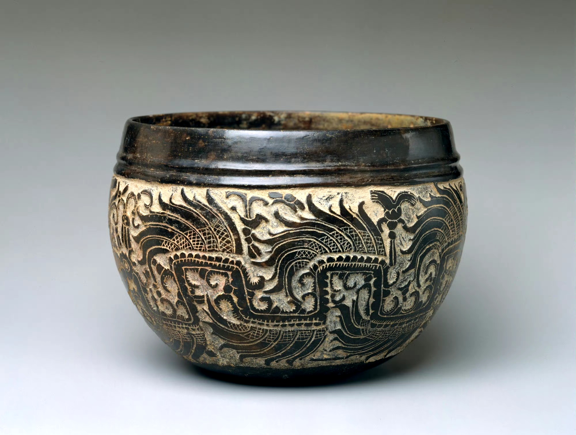 5cm,器体以减地平雕的工艺制作纹饰,内容为羽蛇神和坐姿人像,据认为