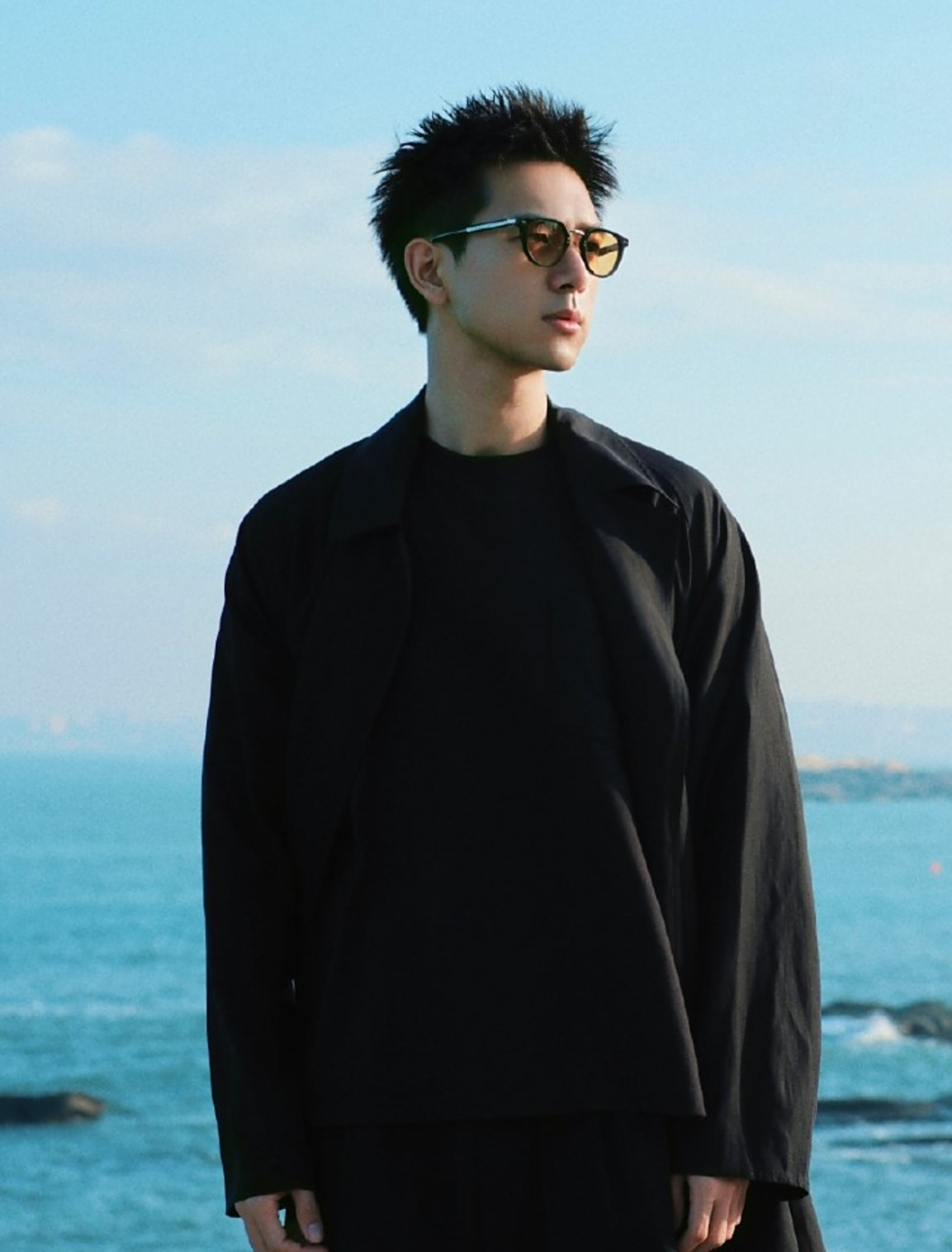 李现晒近照,寸头变长了气质好man,一身黑衣在海边耍帅气场十足.