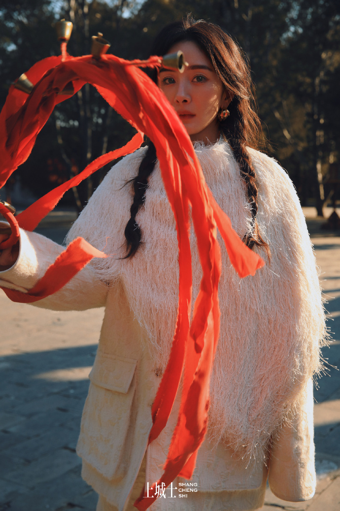 为这座传统的中式古建筑增添了灵动的气息,她时而又手持红绸带,站在石