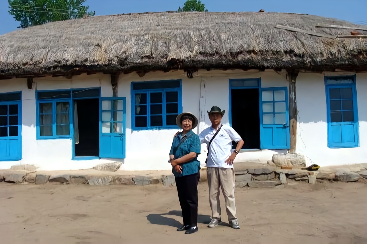 清晨,朝鲜农村雾气未散,白墙青瓦平房在晨光中若隐若现