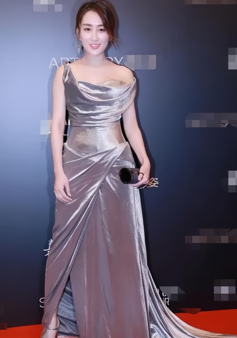 她身穿一袭银色长裙礼服,散发出性感而迷人的魅力.