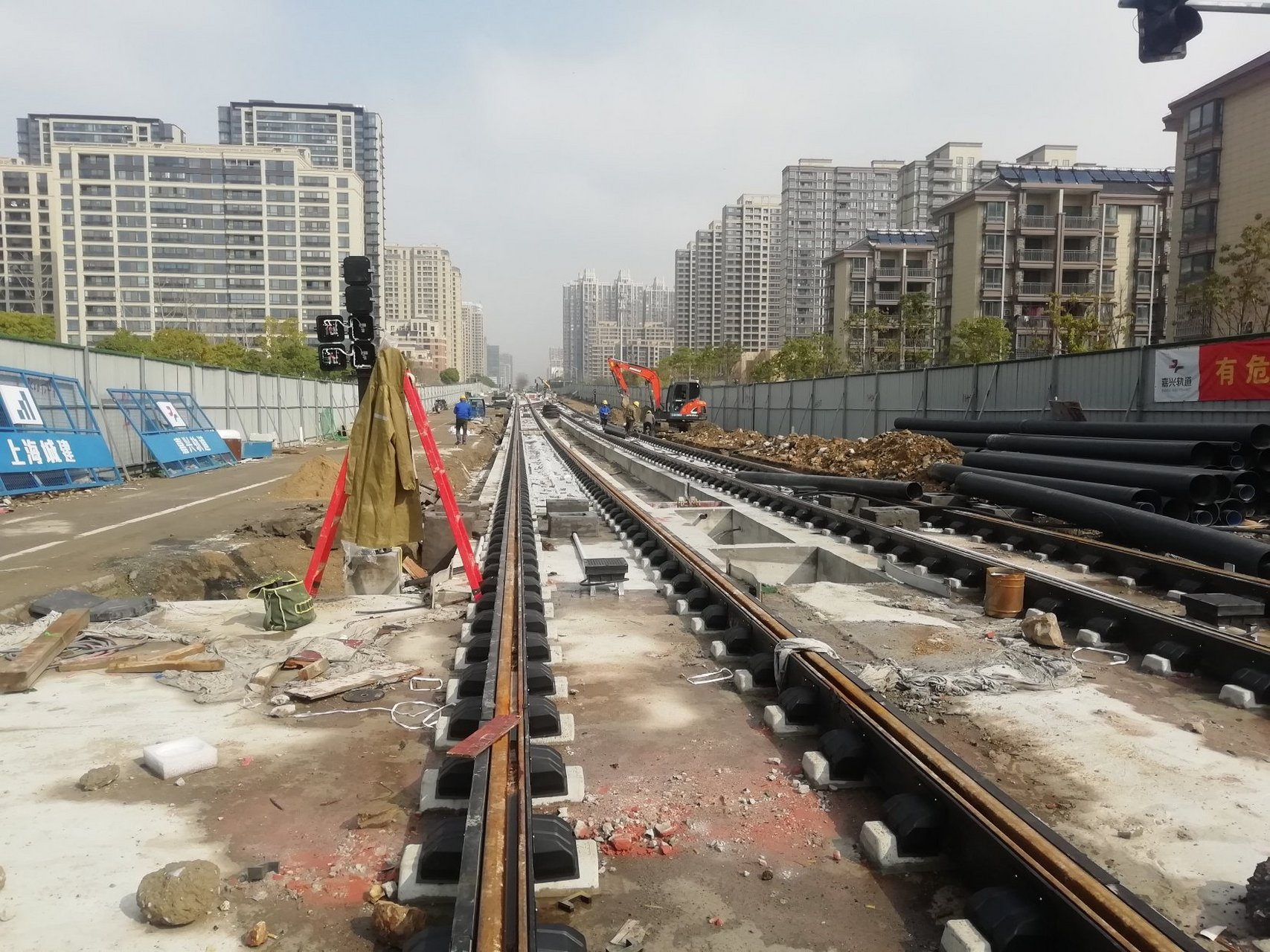 加班加点铺轻轨,百年大庆添新景.