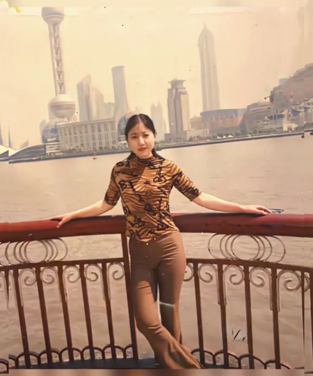 上世纪90年代,一个穿着喇叭裤的姑娘在上海外滩的留影,女孩的穿着打扮