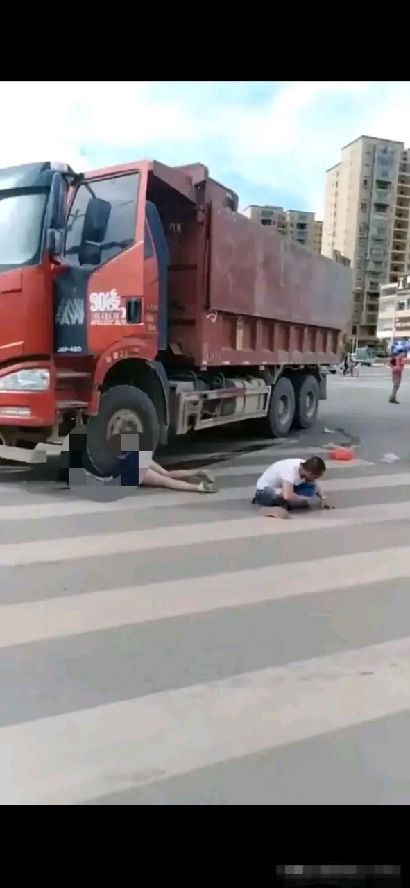 四川成都一辆大货车在斑马线上把路过行人碾压车轮底下,司机蹲在地上