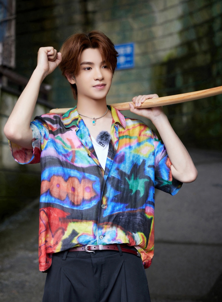 黄明昊参加综艺的穿搭造型,一身彩色印花衬衫,内搭白色v领t恤衫,再