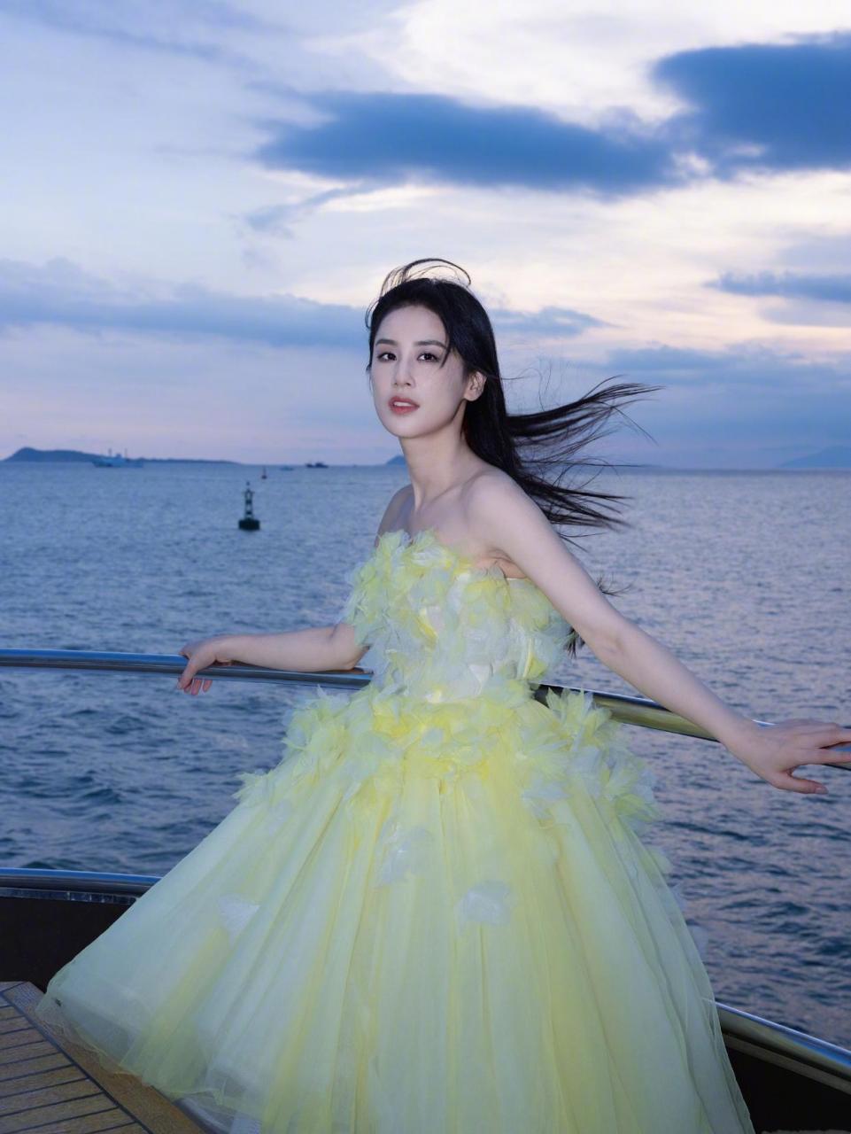 黄圣依身穿一件美丽的彩色礼服,站在海边,享受着海风拂面的感觉.