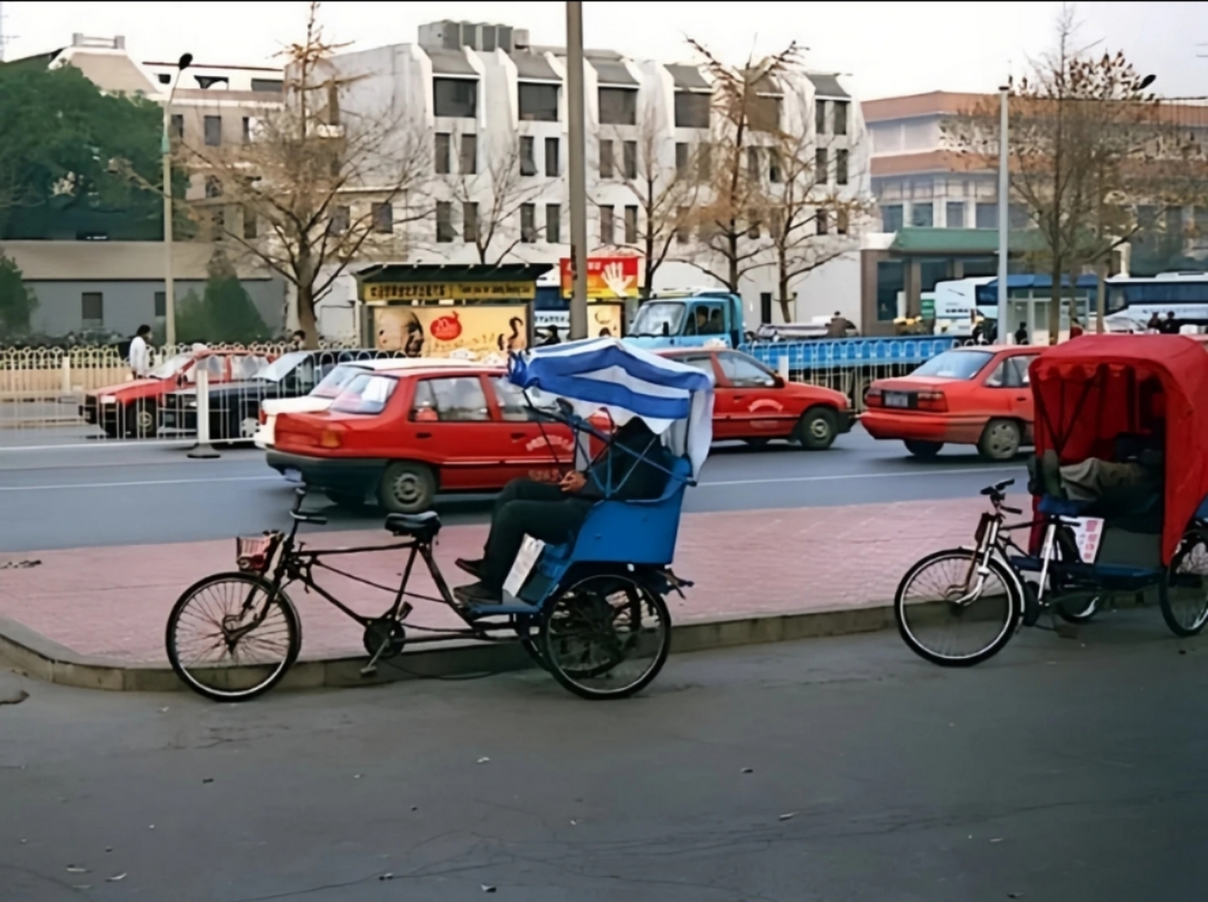 1999年,北京街头老照片,脚蹬三轮车车夫在马路上等人,这种三轮车应该