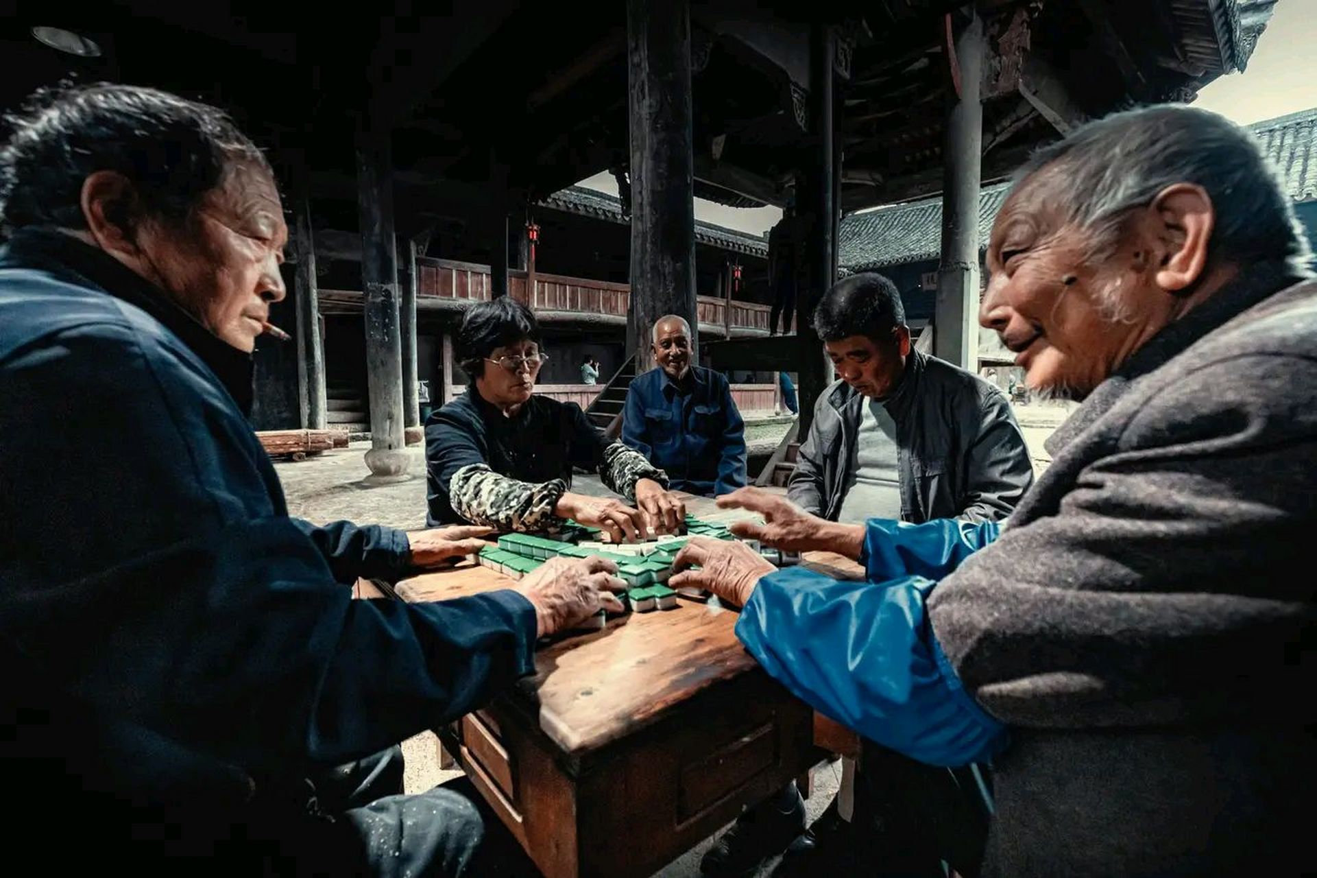 村裡的老人打麻將,手勢可熟練了,整理好麻將後,