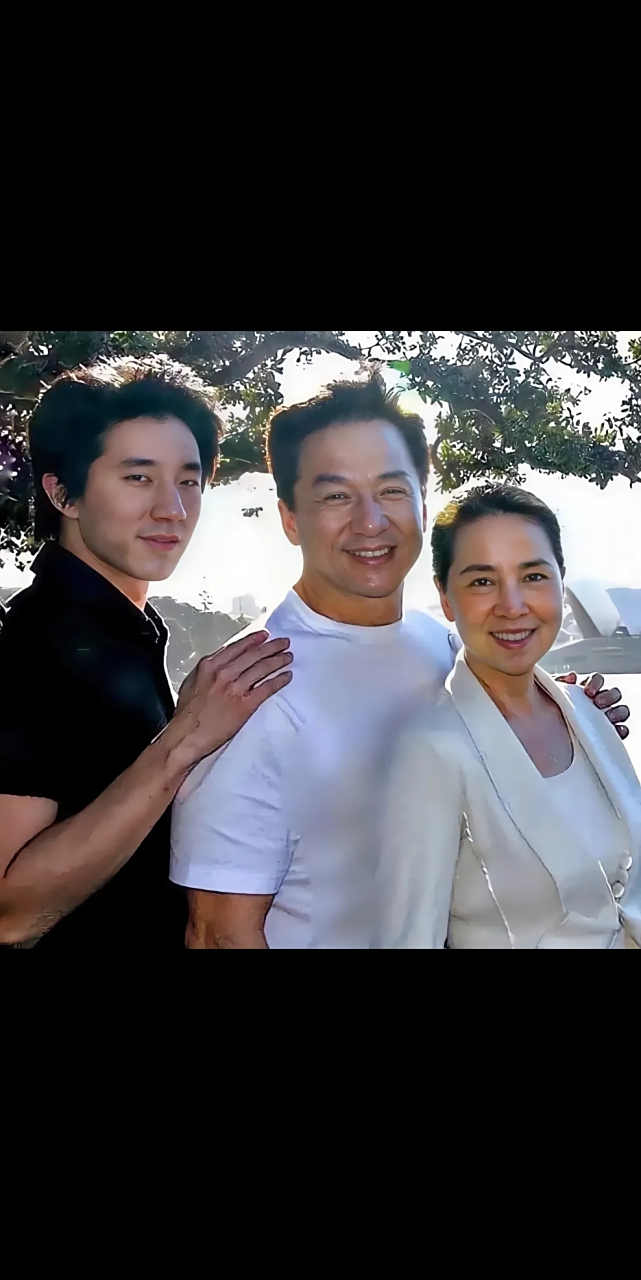 这是一张成龙一家三口的侧身照片,拍摄于一个真实而自然的时刻.