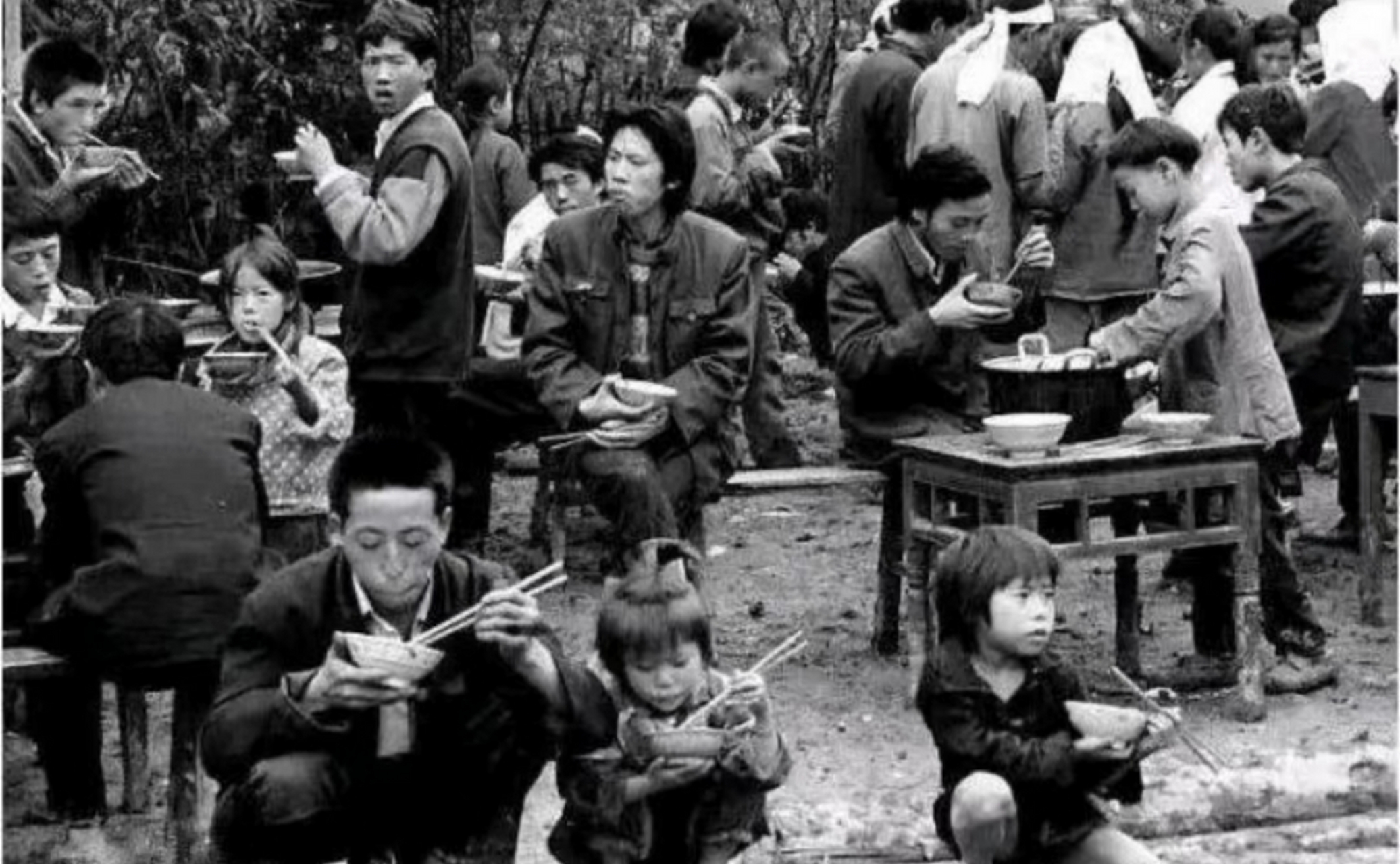 人们拿着碗蹲在地上,或者坐在椅子上吃饭,也没有菜,是饭菜一体的形式!