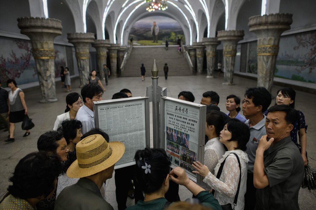 平壤的通勤者在2018年6月读国有报纸《劳动新闻》。该报以巨大篇幅报道了金正恩与特朗普总统在新加坡的会面。