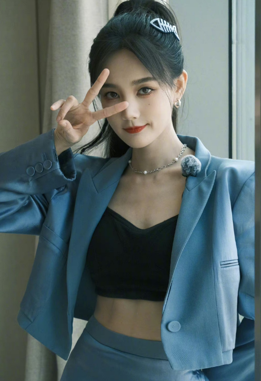 看李一桐这组照片,穿着蓝色套裙的李一桐梳着高马尾,戴着蓝色的鱼骨