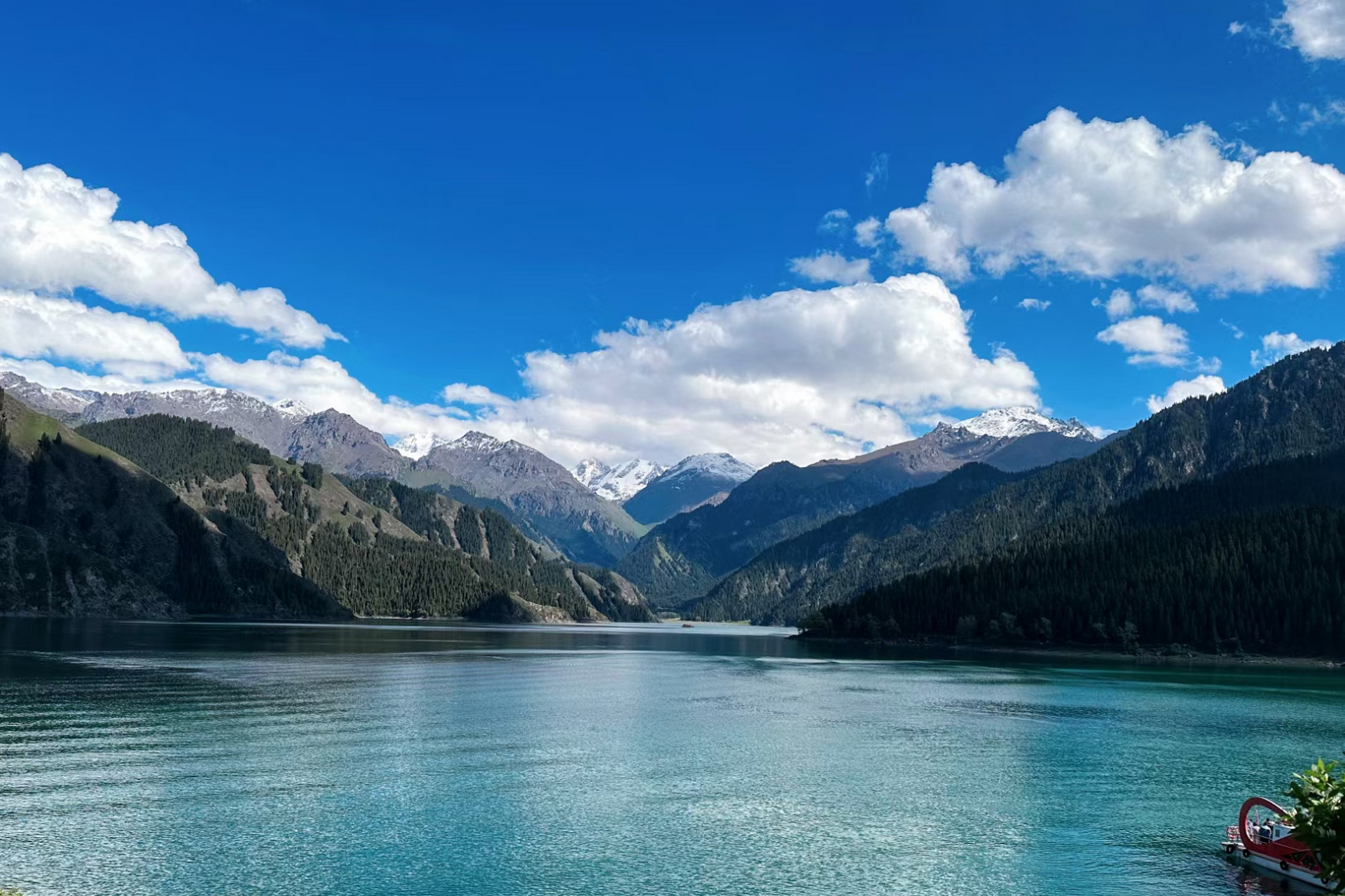 天山天池位于新疆阜康市境内的博格达峰下的半山腰,是一个天然的高山