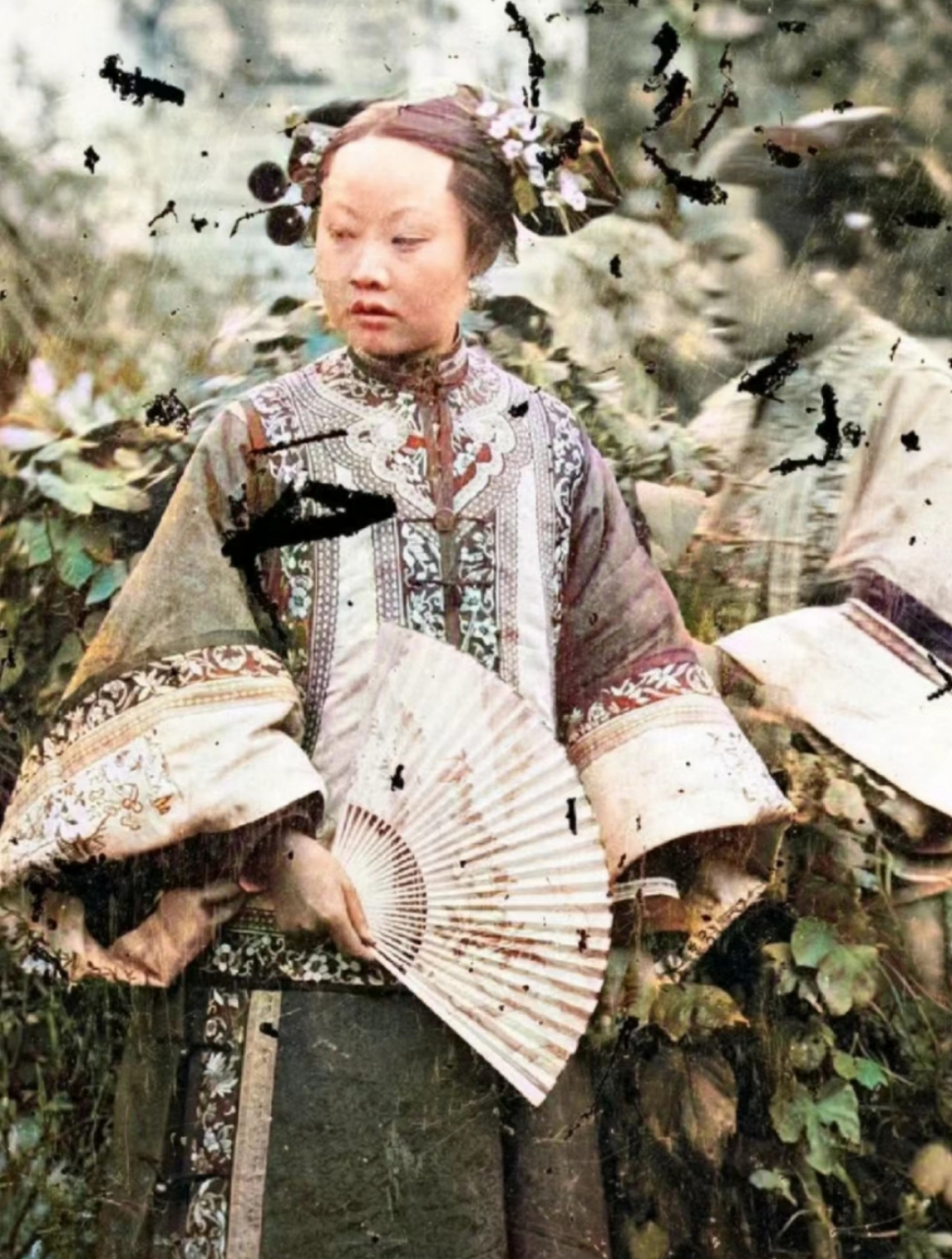 晚清老照片,一位拿着扇子的满族女人,她穿着奢华,一看就是贵妇,满族