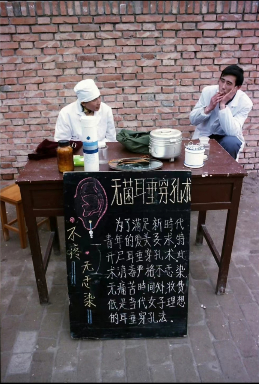1985年,城市街头摆摊打耳洞,摊主穿着白大褂显得很讲究卫生,旁边的人