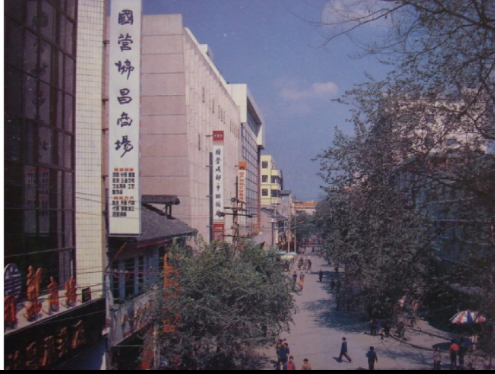 二十世纪八十年代老照片,四川成都街道一角,楼下行人很多,小汽车很少
