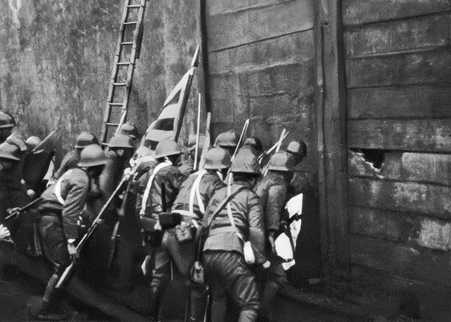 上海四行仓库保卫战,日军试图用楼梯进入仓库内,仓库外围满是弹孔;这