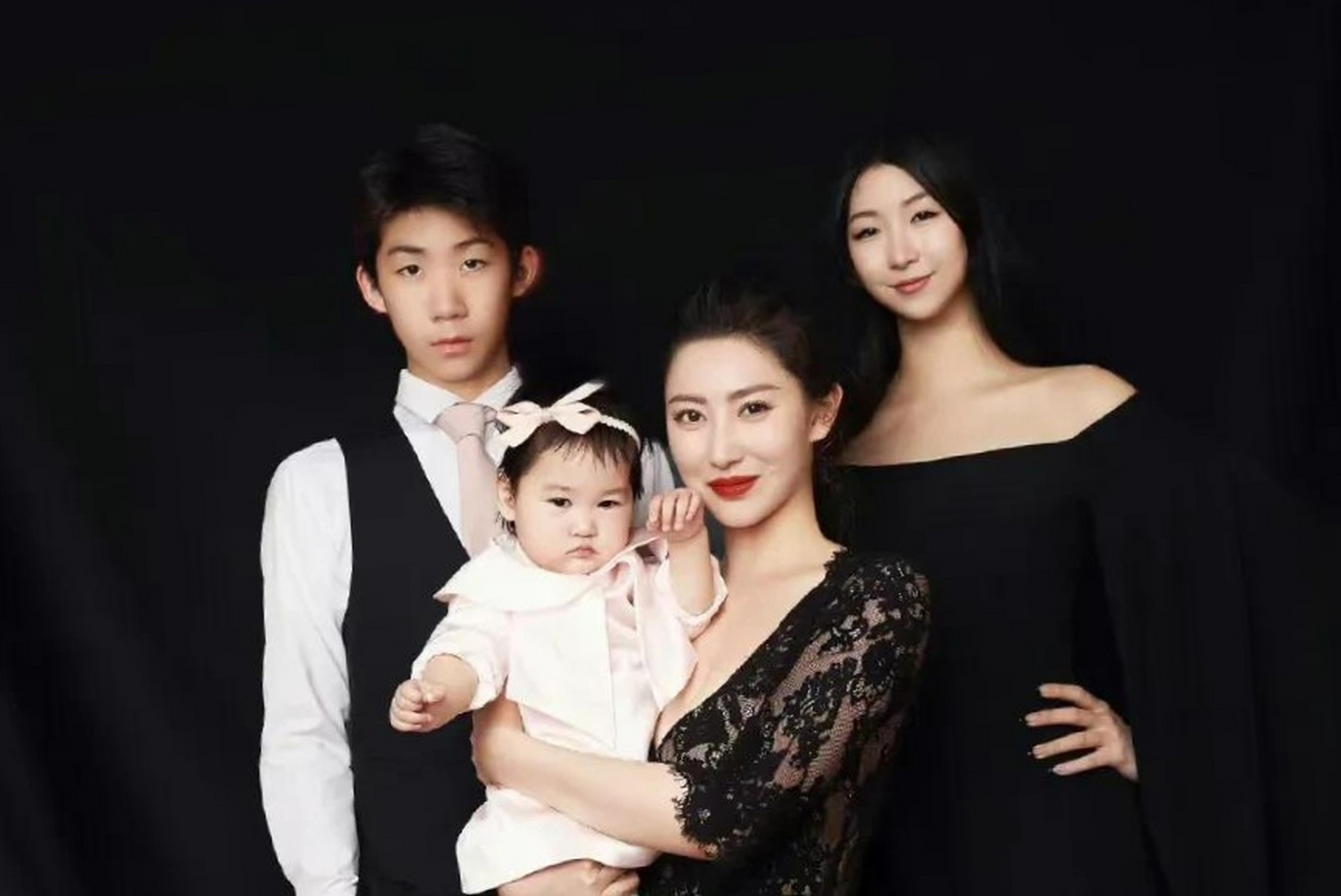 照片中,殷旭抱着自己三胎的女儿,气质典雅.