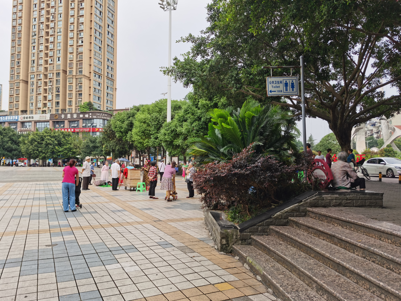 下班路过合川体育馆,发现前面的广场以及路边的台阶上坐满了人,仔细