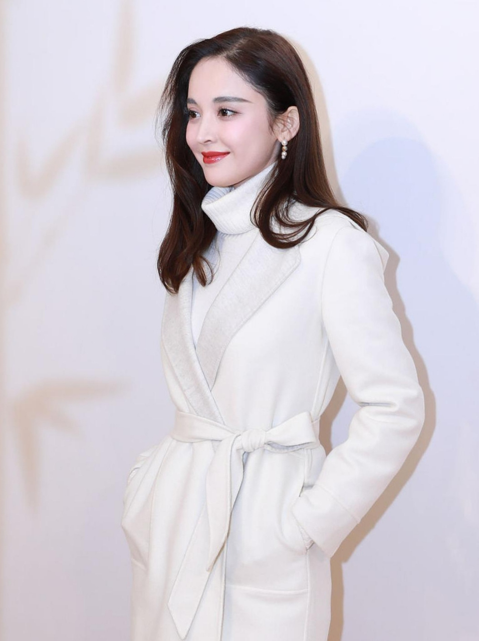 看古力娜扎长发披肩,穿着白色高领羊毛衫,撘配白色腰带裙,肤白貌美