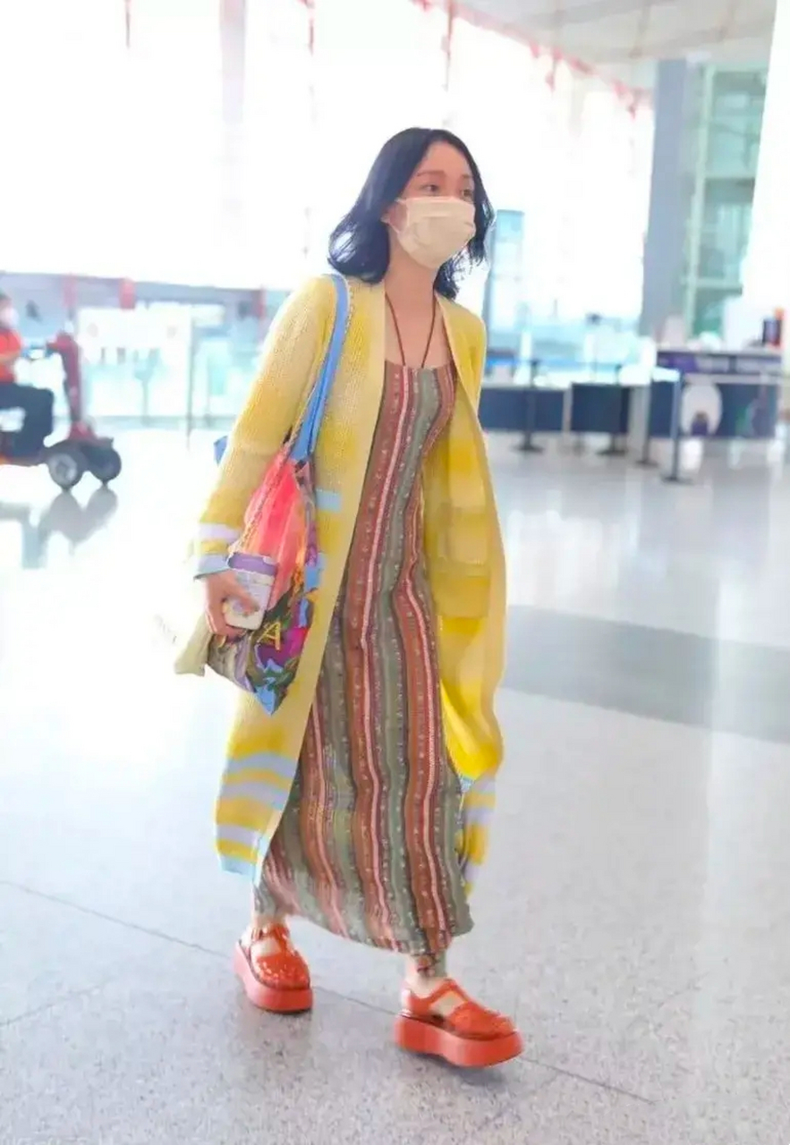 周迅身穿土黄色条纹长裙配浅黄色开衫外搭,脚踩一双杏红色厚底凉鞋