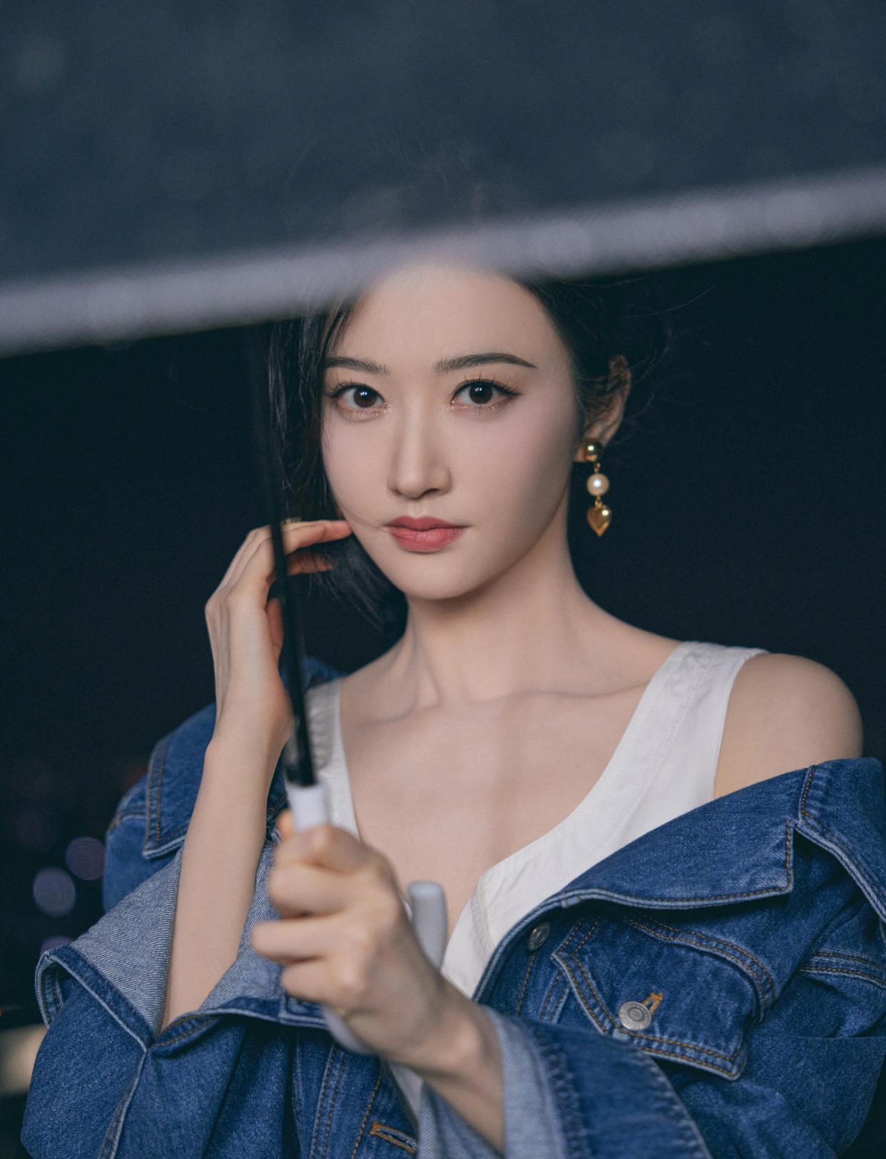 景甜穿白色连衣裙外搭牛仔外套,清新文艺,撑着雨伞营造唯美氛围