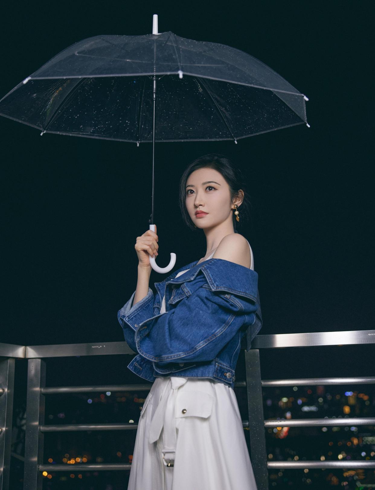 景甜穿白色连衣裙外搭牛仔外套,清新文艺,撑着雨伞营造唯美氛围