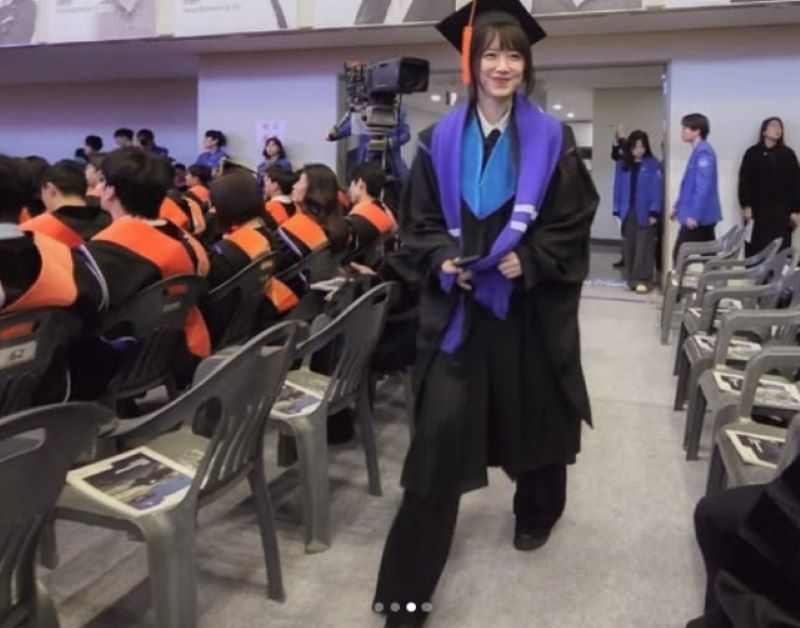 获得硕士学位的具惠善在毕业典礼现场，穿着学术袍面带灿烂笑容