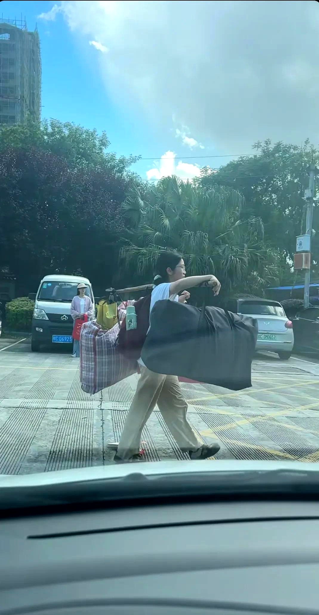 视频里,有个高三女孩正自己背着行李回家,她一个人走在大街上,脚步