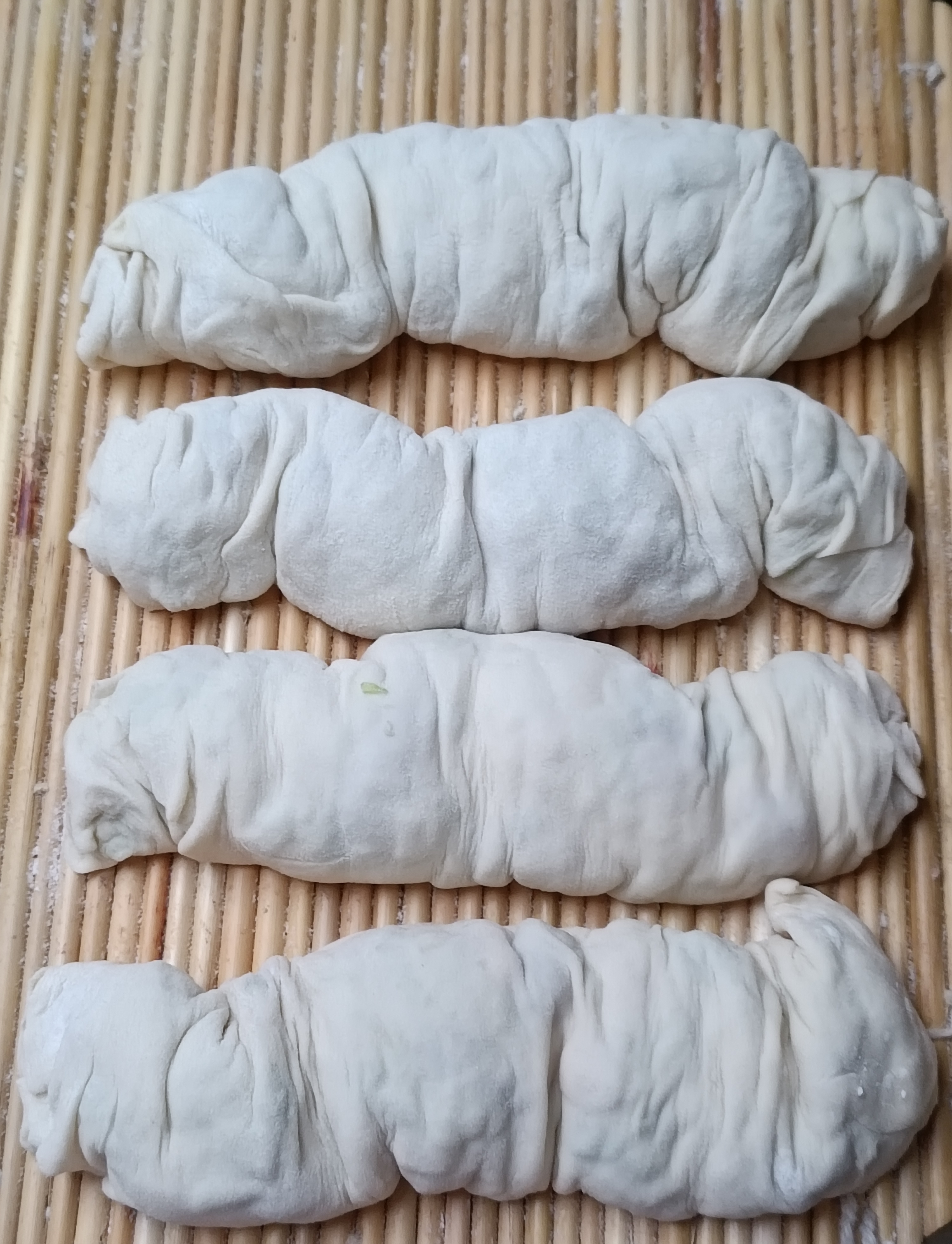 用白菜和大葱调的馅和一块不软不硬的面团擀一张大饼把调好的馅