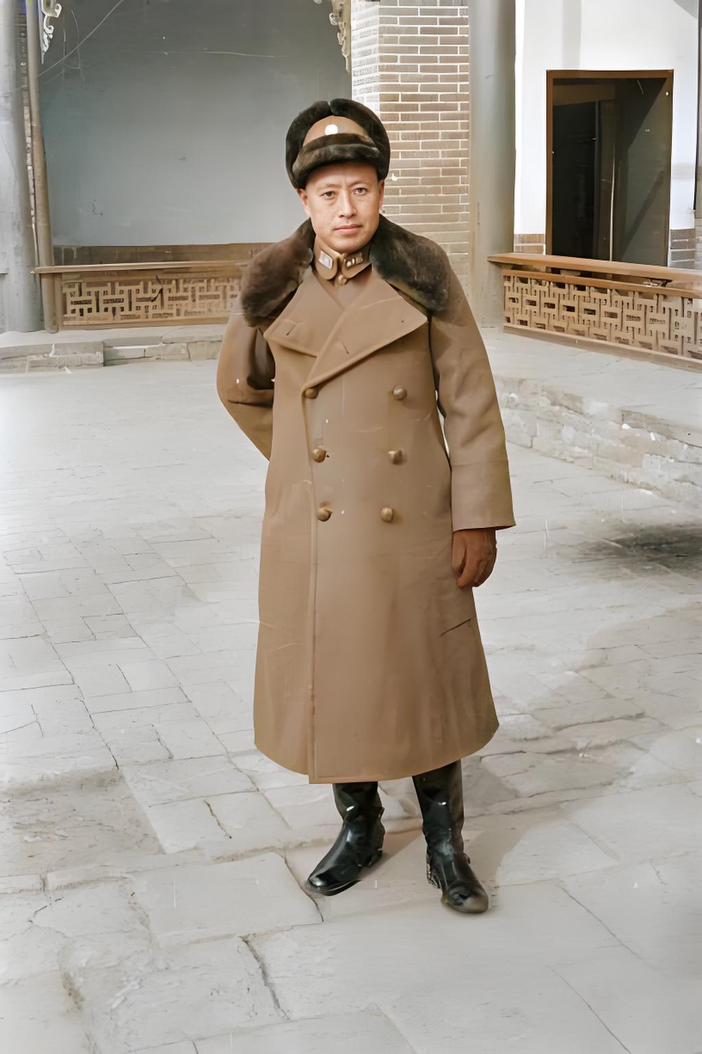 照片中的于学忠将军身着长款军大衣,大衣领口和帽子边缘都有厚实的毛